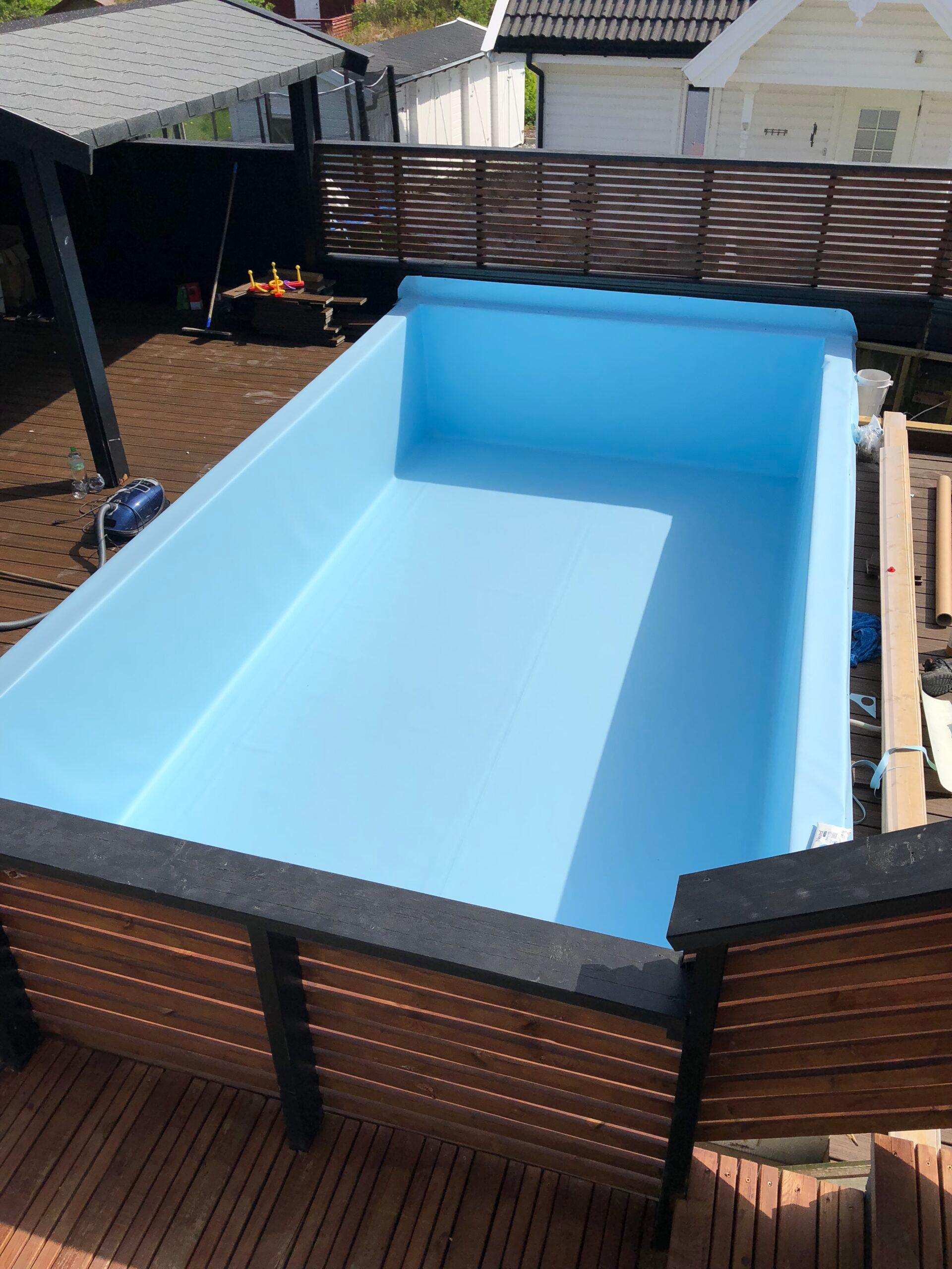 A pool lined with blue membrane, set into a wooden deck