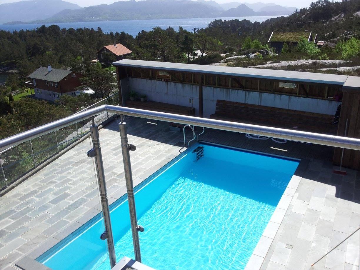 A pool lined with blue membrane on a terrace with a glass railing