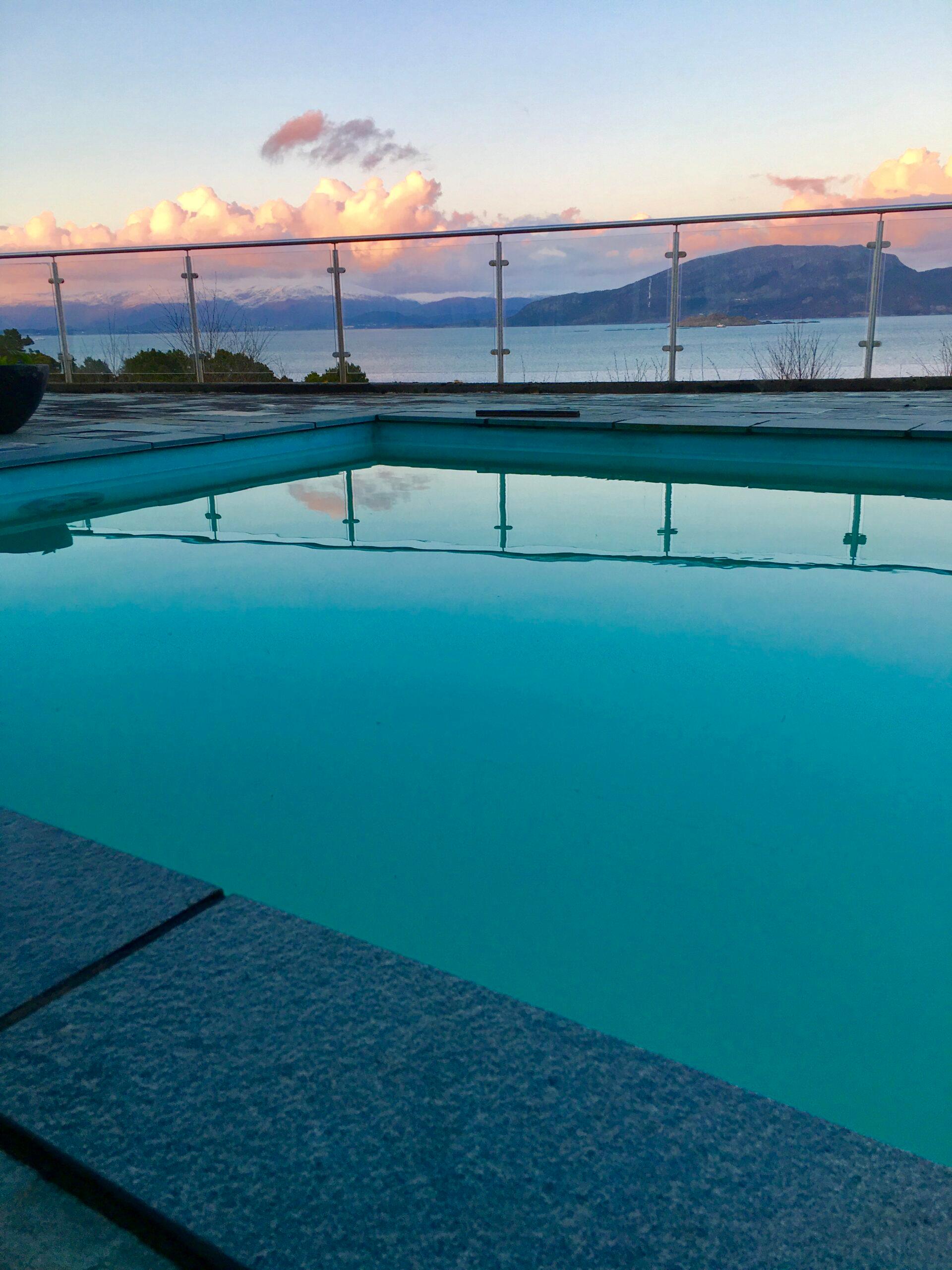 A pool lined with membrane on a roof terrace, at sunset over the town