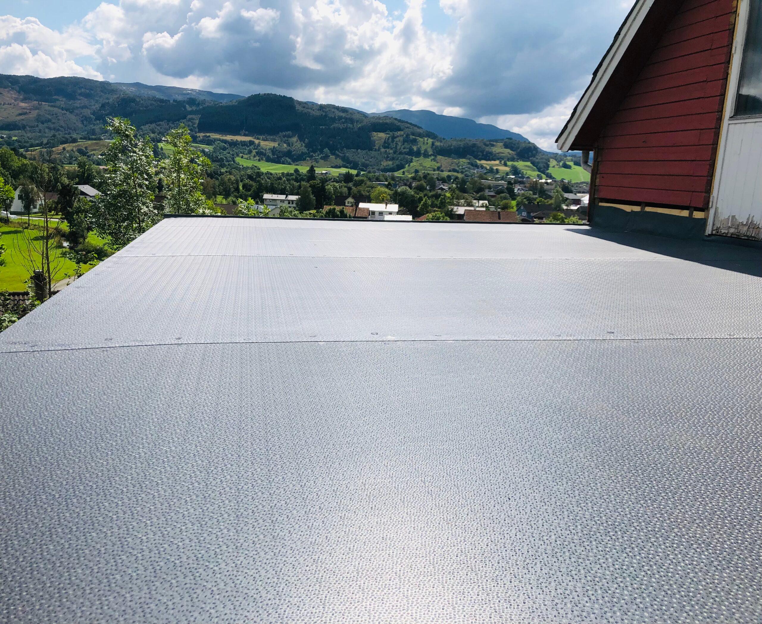 A terrace sealed with a grey membrane, with hills behind